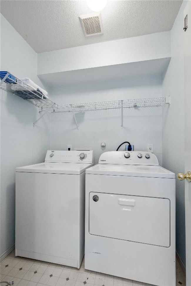 Clothes washing area featuring laundry area, visible vents, independent washer and dryer, and a textured ceiling | Image 28