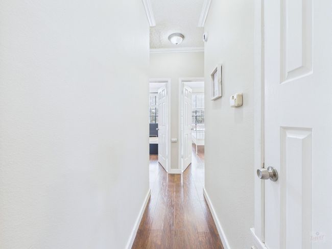 Hall with crown molding, dark wood-style floors, and a textured ceiling | Image 15
