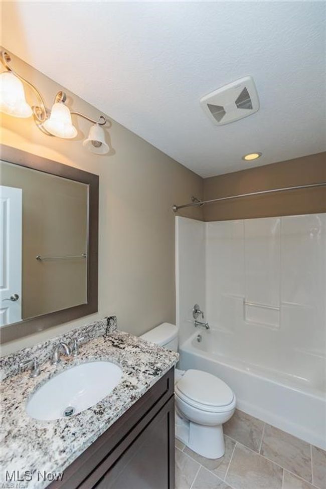 Bathroom featuring visible vents, toilet, shower combination, and vanity | Image 6
