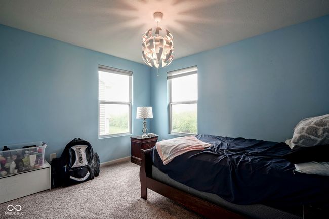 carpeted bedroom with a chandelier and baseboards | Image 29
