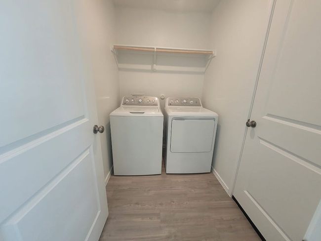 Washroom featuring washing machine and dryer and light wood vinyl style flooring | Image 16