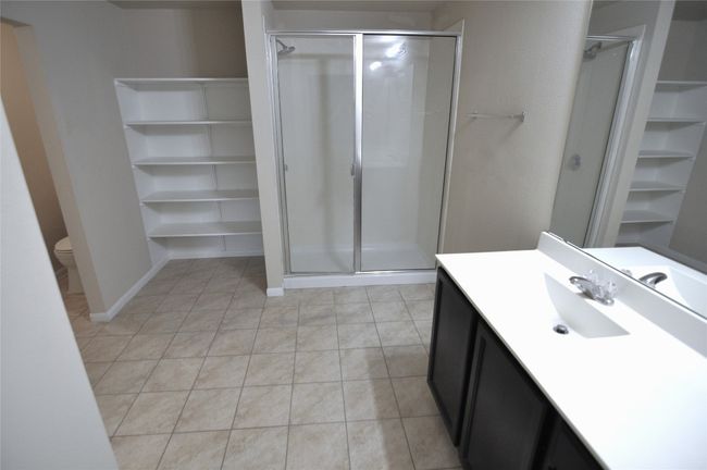 Bathroom with tile patterned floors, a shower stall, and vanity | Image 20