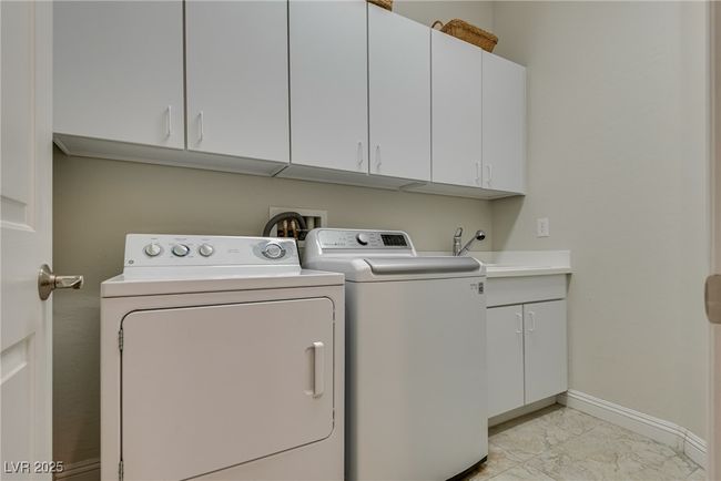 Clothes washing area with marble finish floor, cabinet space, baseboards, and washer and clothes dryer | Image 11