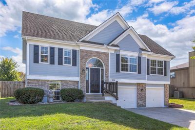 Split foyer home with a front yard, cooling unit, and a garage | Image 2