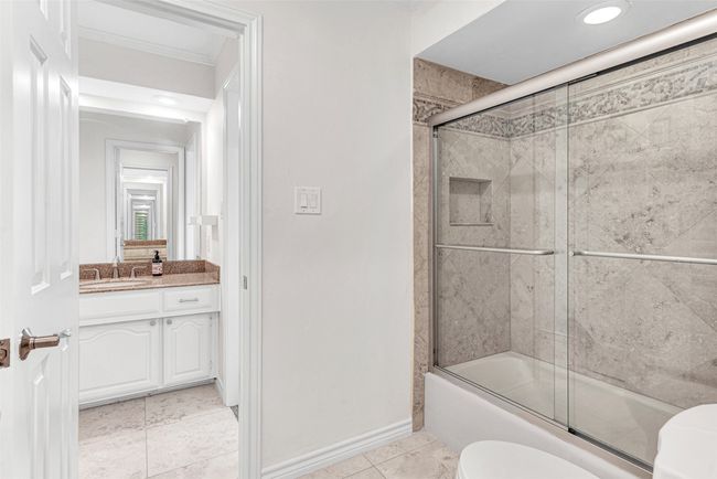 The jack & jill bath features fresh wall and cabinet paint, replaced hardware and a shower/tub combination with glass doors and shower head with removable sprayer, plus a Toto toilet! | Image 28