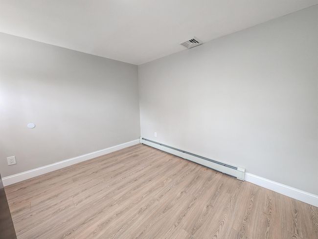 Unfurnished room with baseboards, a baseboard radiator, visible vents, and light wood-style floors | Image 18