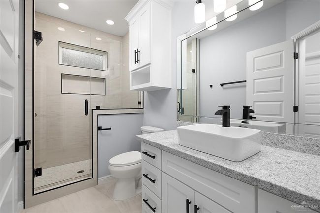 Bathroom featuring toilet, a shower stall, vanity, recessed lighting, and tile patterned floors | Image 12