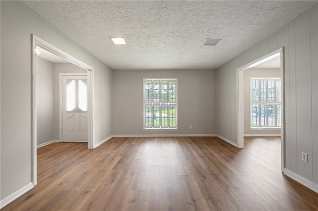 Spare room featuring wood finished floors, baseboards, and a textured ceiling | Image 4