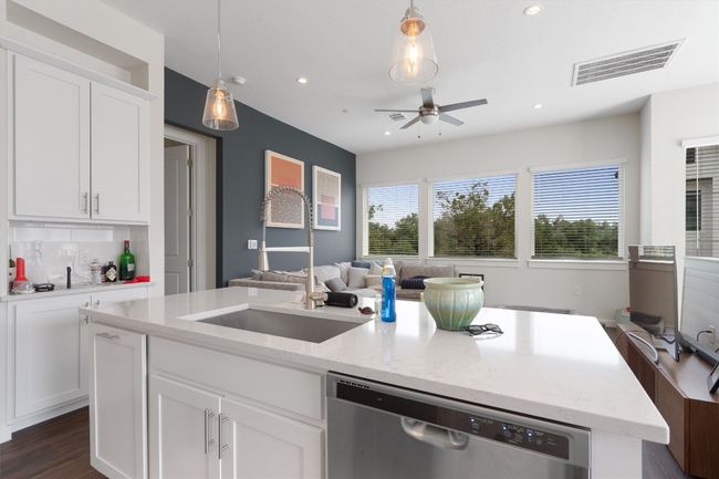 Kitchen featuring dishwasher, a ceiling fan, a kitchen island with sink, open floor plan, and white cabinets | Image 22