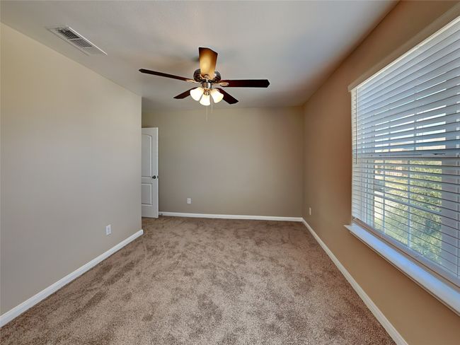 Carpeted empty room with ceiling fan and baseboards | Image 17