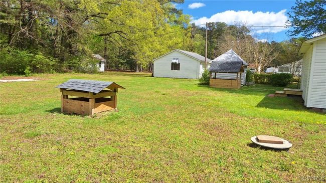 View of yard with a storage unit and an outdoor structure | Image 43