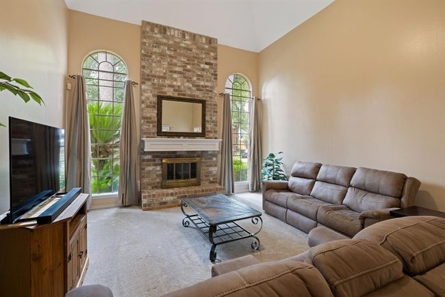 A beautiful 2-story fireplace takes center stage, making this an extra cozy room to relax in with friends and family. | Image 10