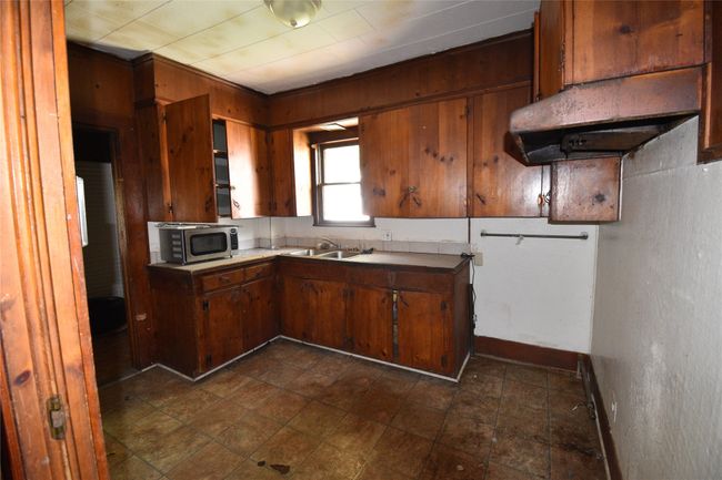 Kitchen featuring stainless steel microwave, brown cabinets, and light countertops | Image 12