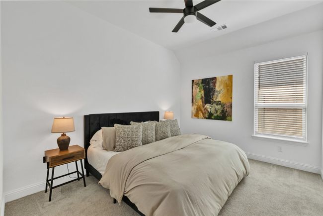 Bedroom featuring light colored carpet, lofted ceiling, baseboards, and a ceiling fan | Image 21