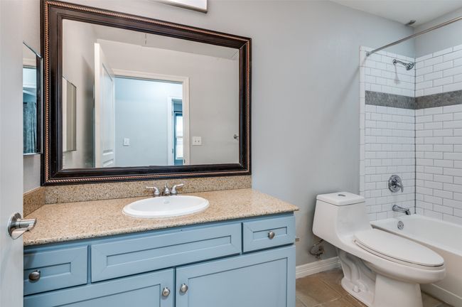 Full bathroom with vanity, tiled shower / bath, tile patterned floors, and toilet | Image 15