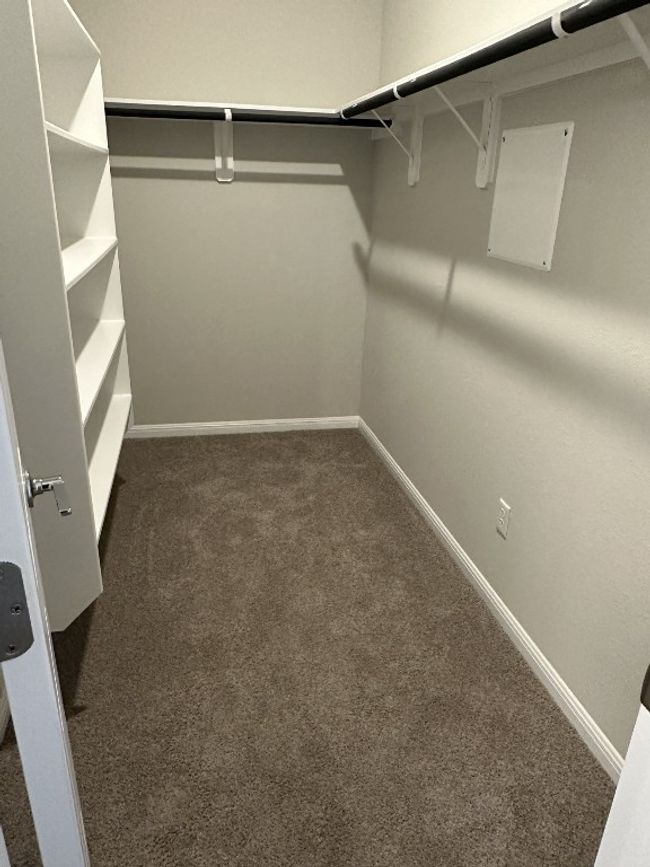 Walk in closet featuring dark colored carpet | Image 10