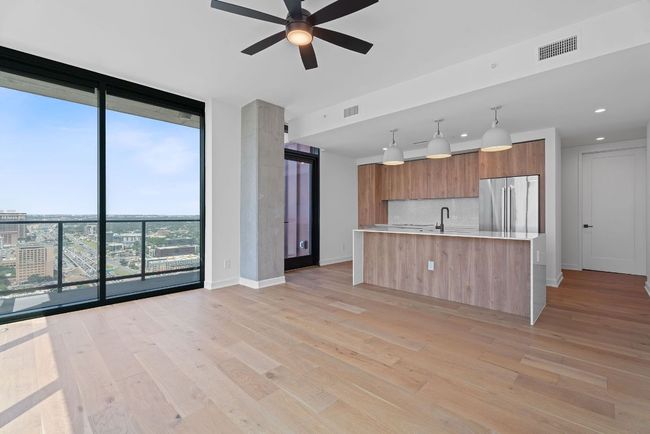 Kitchen with stainless steel refrigerator, expansive windows, modern cabinets, light countertops, and decorative backsplash | Image 4