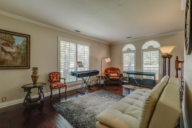 Living area featuring crown molding and dark wood-style flooring | Image 5
