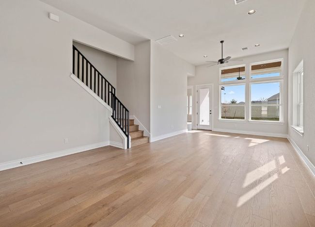 Unfurnished living room featuring recessed lighting, stairs, ceiling fan, light wood finished floors, and visible vents | Image 5