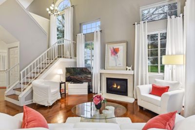 As you enter, you'll be greeted by a generous living room featuring a vaulted ceiling, stunning floors and a gas-burning fireplace. | Image 2