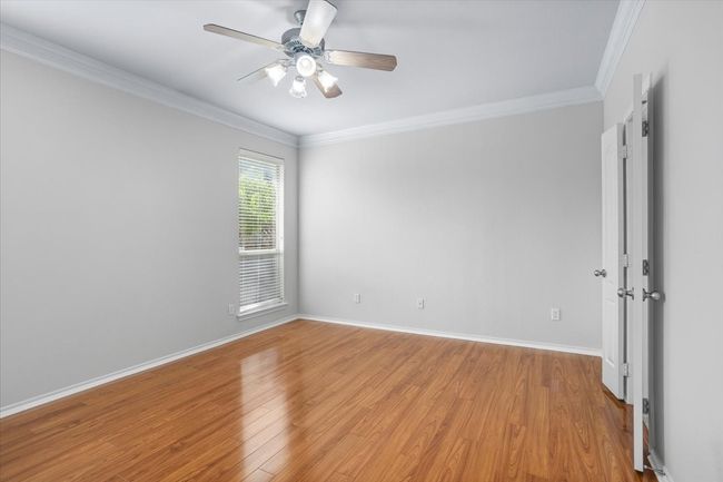 Primary bedroom with windows looking out to the back yard | Image 12