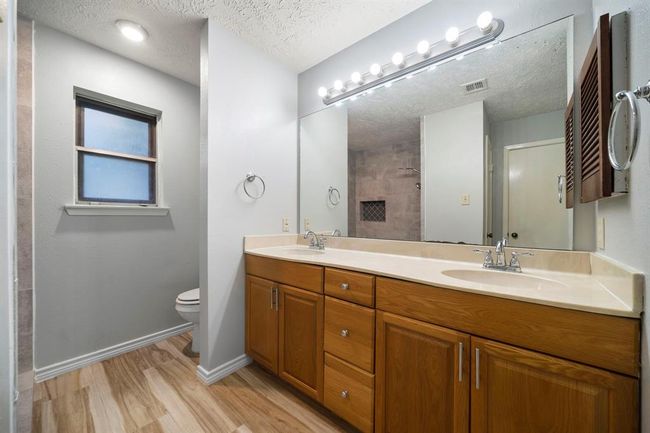 Double-sink vanity with ample storage and updated lighting provides practicality for daily routines. | Image 24