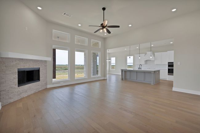 Unfurnished living room with light wood-style flooring, a stone fireplace, recessed lighting, and ceiling fan | Image 7