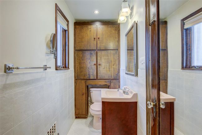 Bathroom featuring tile walls, vanity, tile patterned flooring, and a wainscoted wall | Image 19