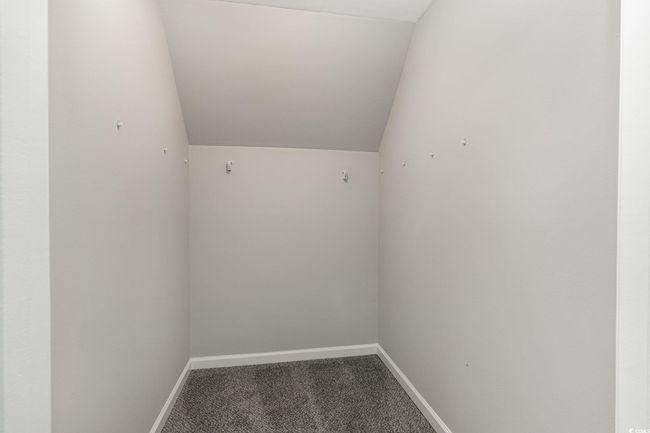Interior space featuring baseboards, vaulted ceiling, and carpet floors | Image 10