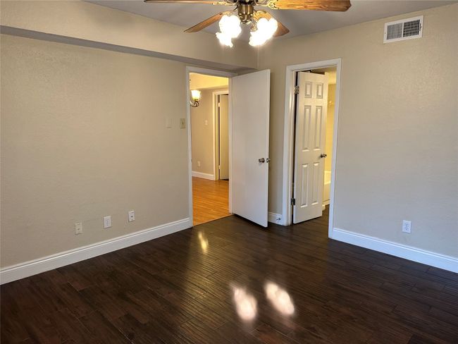 Empty room featuring a ceiling fan and wood finished floors | Image 15