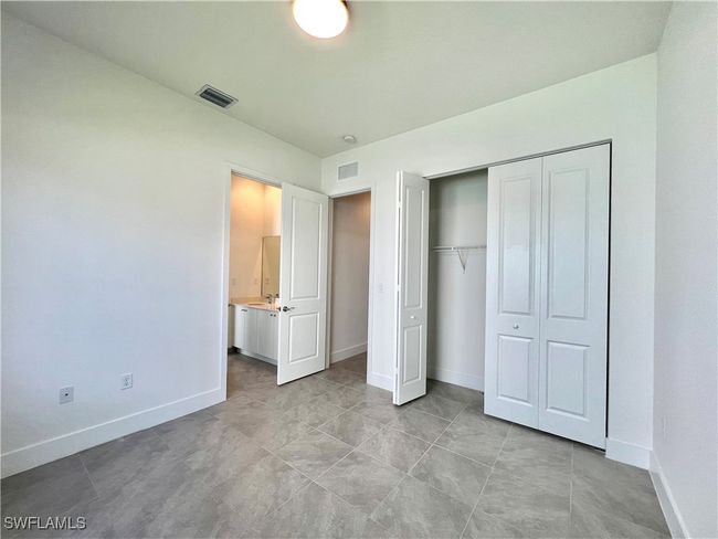 Unfurnished bedroom with a closet and light tile patterned flooring | Image 29