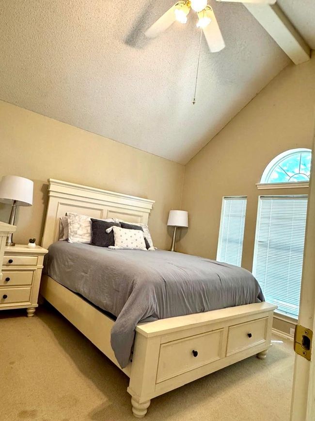 Carpeted bedroom with ceiling fan, lofted ceiling with beams, and a textured ceiling | Image 17