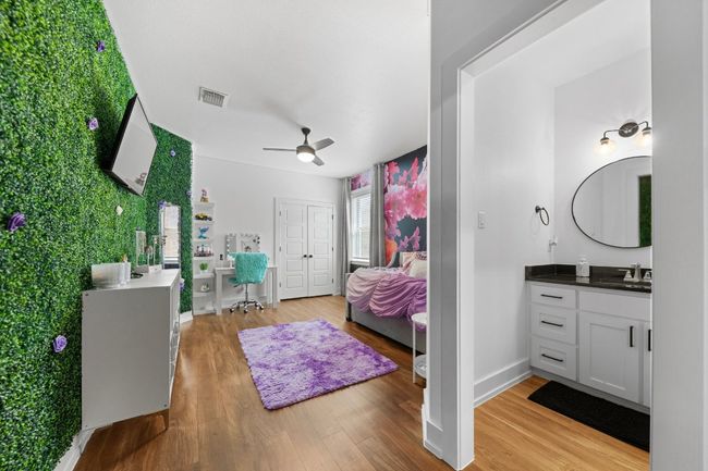 Bedroom with light wood-style floors, ceiling fan, visible vents, a sink, and baseboards | Image 30