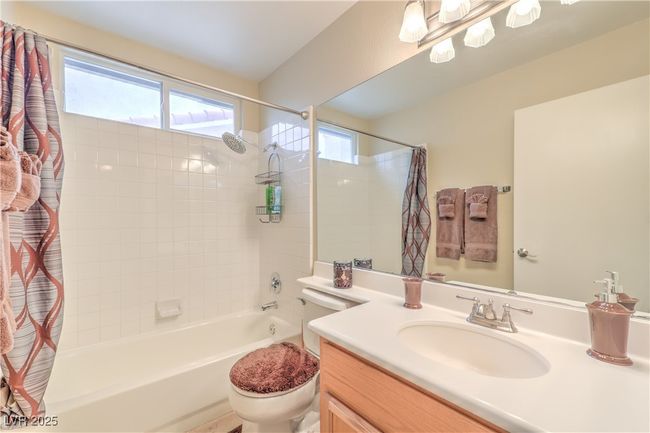 Full bath featuring shower / bath combo, vanity, and plenty of natural light | Image 13