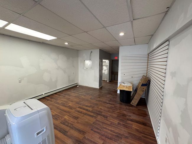 Basement with a paneled ceiling and dark wood-type flooring | Image 7