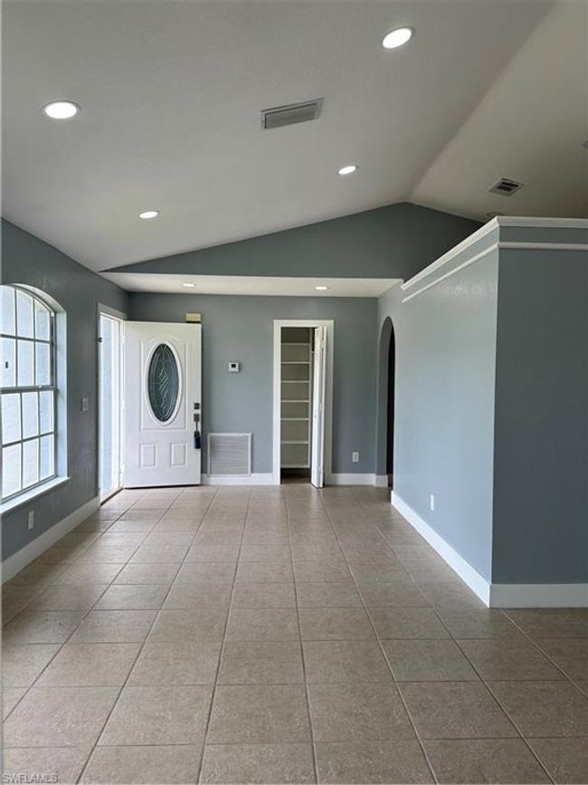 Tiled entrance foyer featuring arched walkways, lofted ceiling, and recessed lighting | Image 8