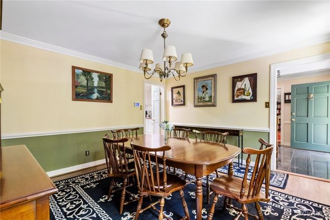 Dining area featuring a chandelier, ornamental molding, and wood finished floors | Image 7