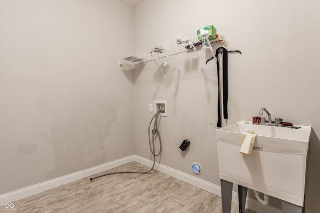 laundry room featuring a sink, baseboards, washer hookup, wood finished floors, and laundry area | Image 25