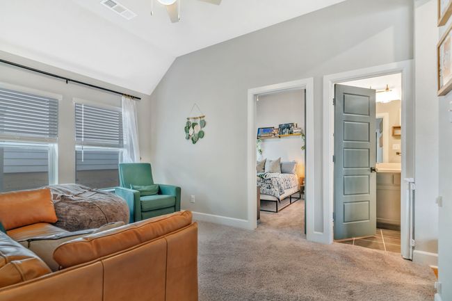 Carpeted living area featuring a ceiling fan and lofted ceiling | Image 21