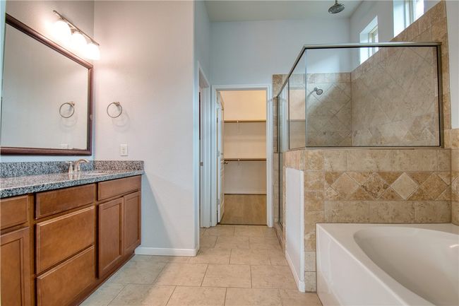 Bathroom with vanity, a spacious closet, baseboards, a stall shower, and a garden tub | Image 17