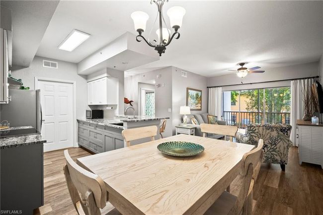 Dining room with ceiling fan with notable chandelier, visible vents, and light wood-style flooring | Image 26