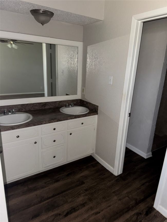 Bathroom featuring double vanity, wood finished floors, baseboards, and ceiling fan | Image 14