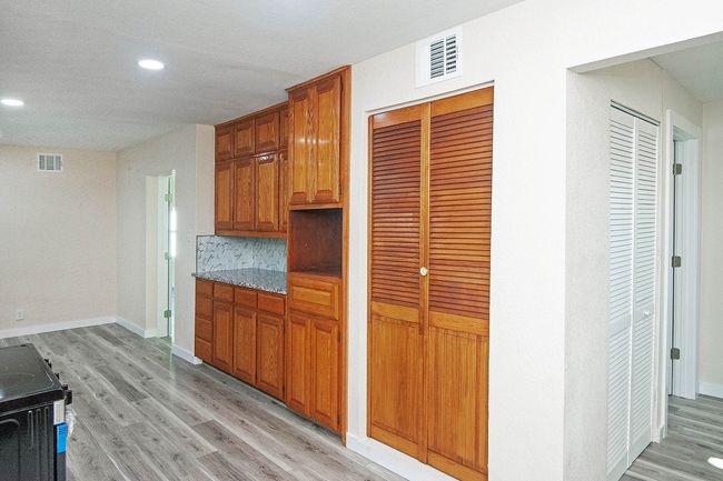 Kitchen with light wood-style floors, recessed lighting, brown cabinetry, and range with electric cooktop | Image 12