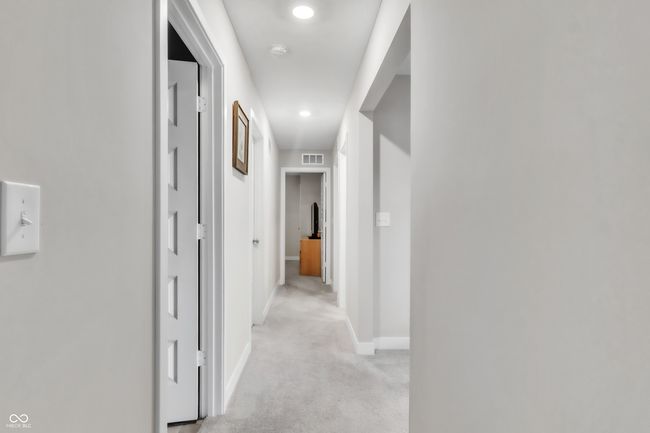 hallway featuring visible vents, baseboards, recessed lighting, and light carpet | Image 22