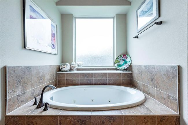 Jetted tub with large privacy window and tile backsplash. | Image 37