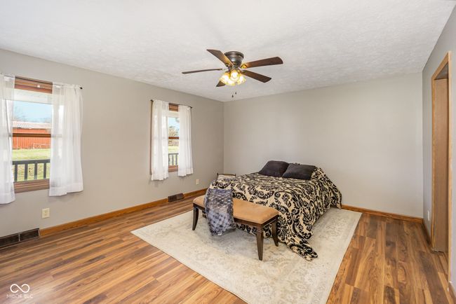 bedroom with baseboards, visible vents, a textured ceiling, and wood finished floors | Image 13