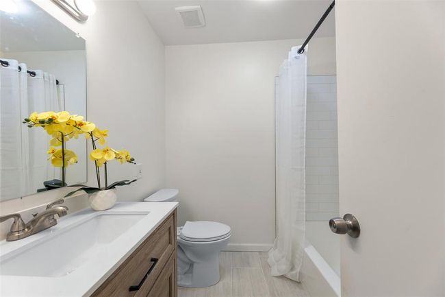 Renovated bathroom with modern fixtures and tiled walls. | Image 26