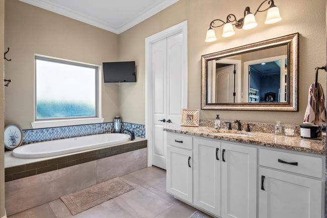 Primary Ensuite featuring vanity, a garden tub, crown molding, and tile patterned flooring | Image 18