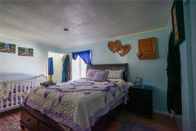 Bedroom with wood finished floors, a textured ceiling, and crown​​‌​​​​‌​​‌‌​‌‌​​​‌‌​​‌‌​‌​​​​​‌ molding | Image 16