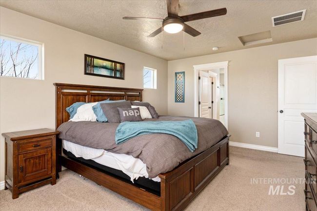 Bedroom with light carpet, attic access, a textured ceiling, and ceiling fan | Image 12